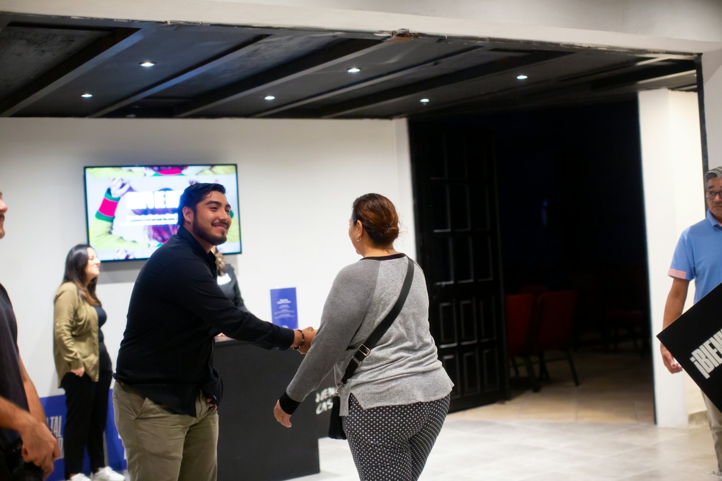 Two people shaking hands at a community event.